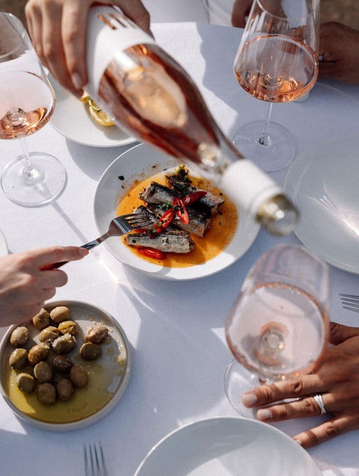 Table avec des pates et du vin rose a Saint-Tropez